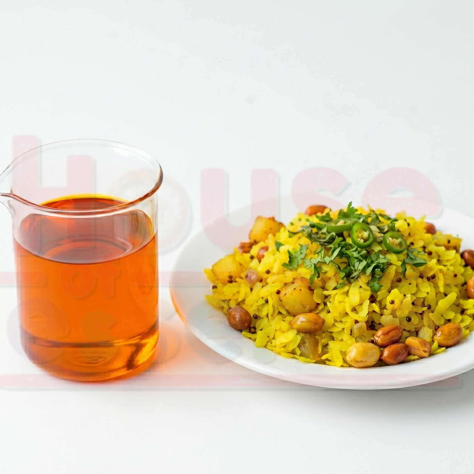 Plate of yellow rice with beans and a glass of orange juice on a white background