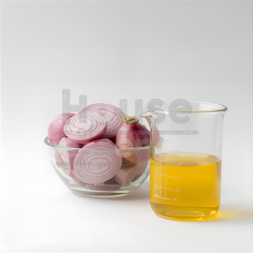 Onion slices in a glass bowl with a measuring cup of yellow liquid on a white background